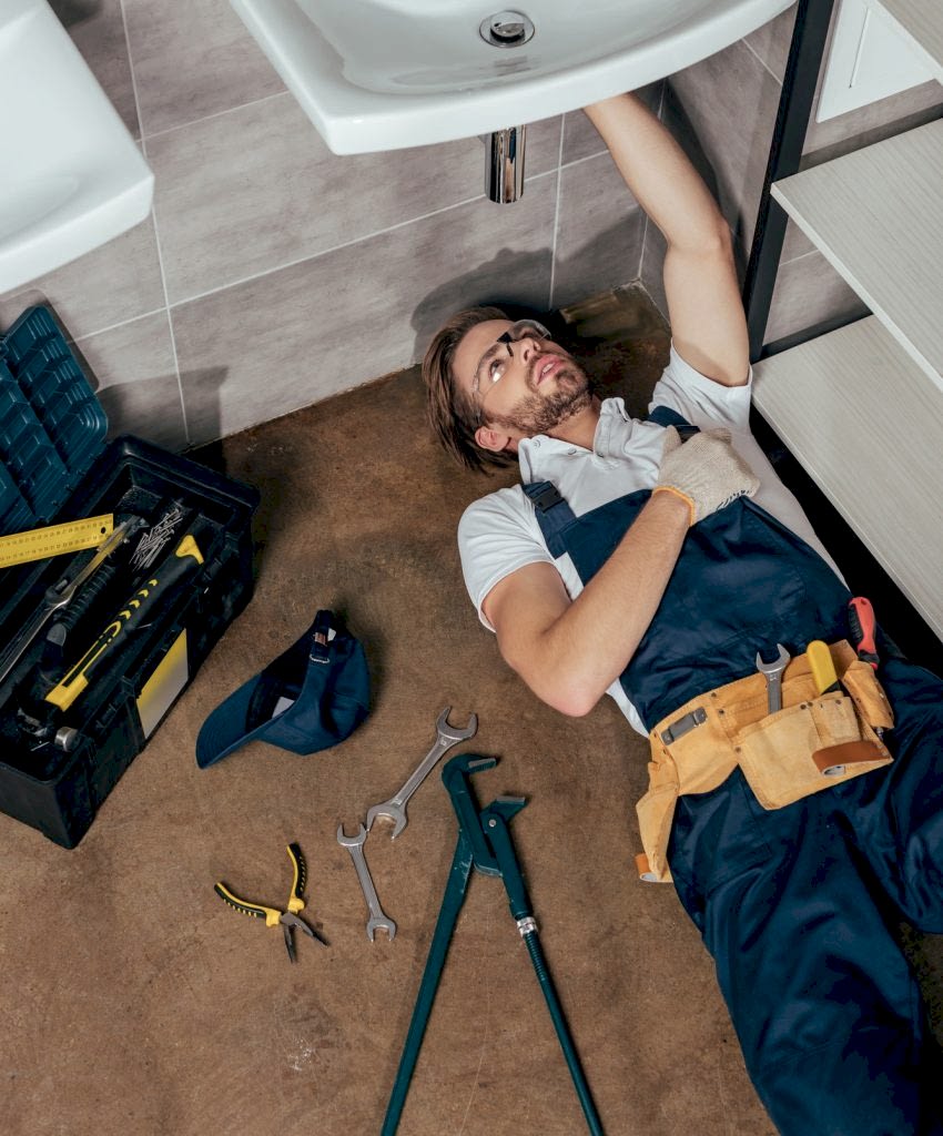 high-angle-view-of-young-male-plumber-fixing-sink-in-bathroom.jpg